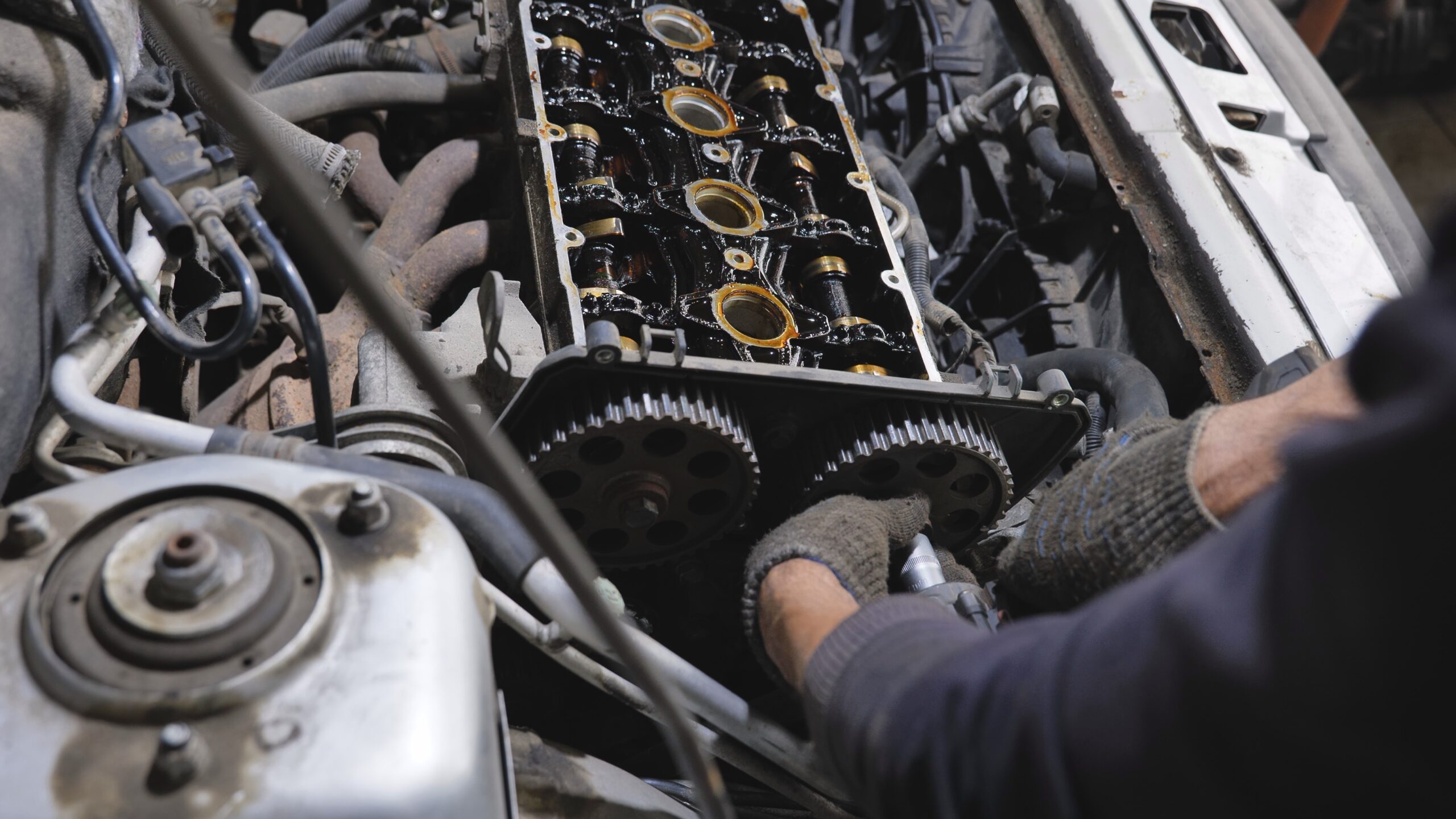 Mechanic working on car engine repair in a garage