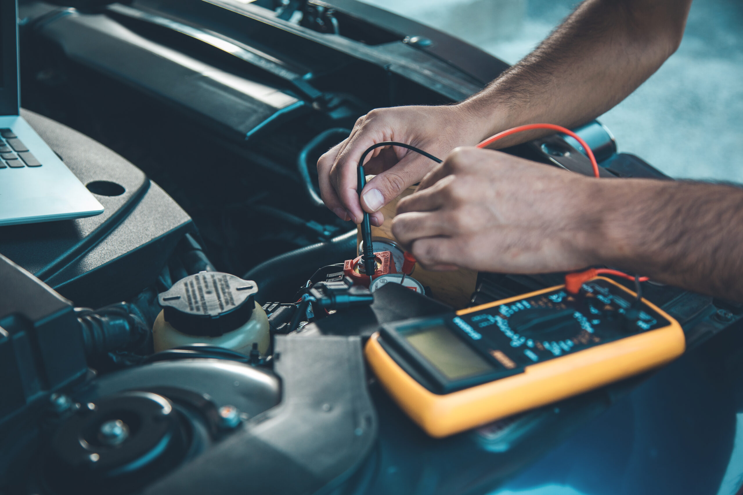 worker hand computer with tester on car