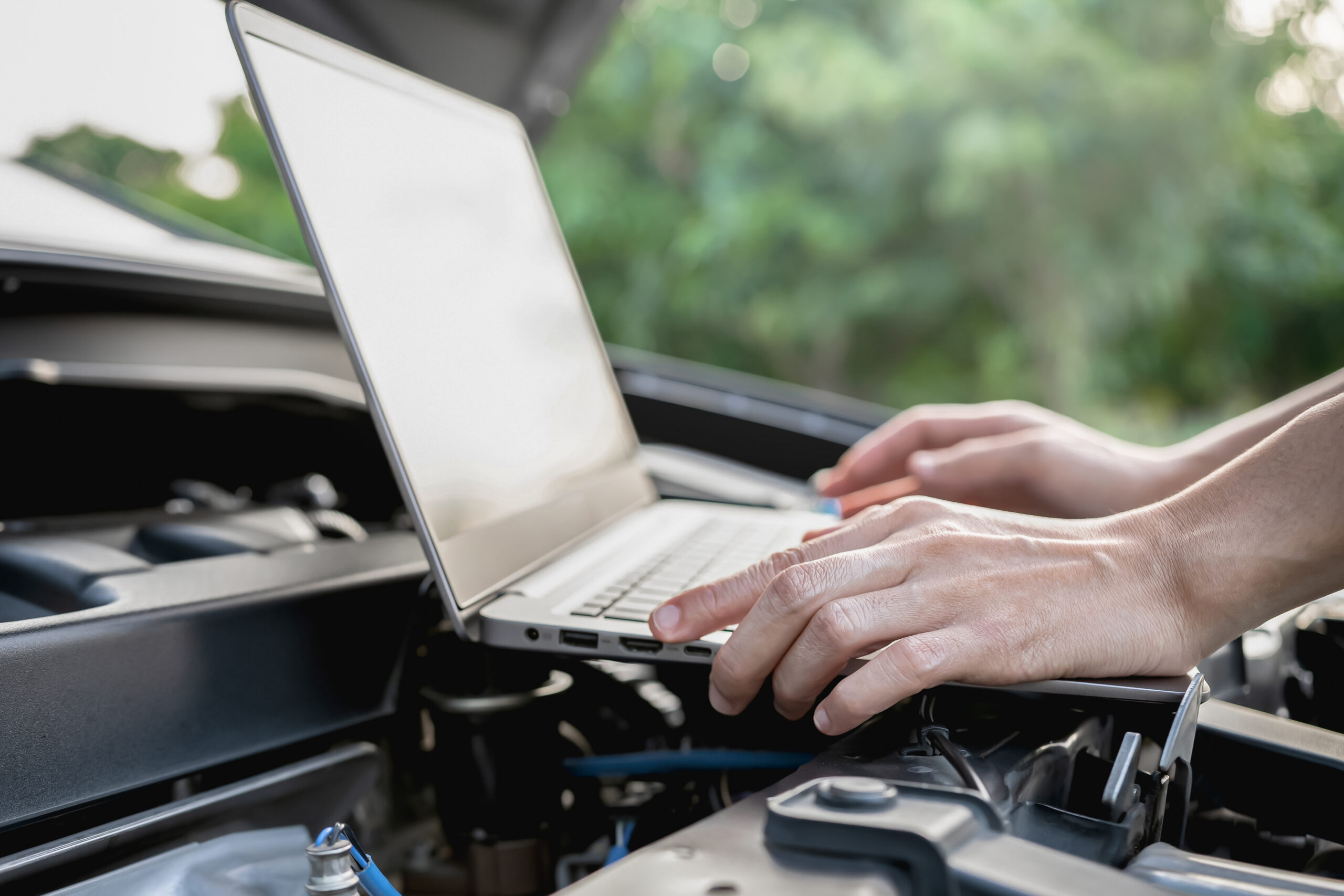 Close up hand women use computer Analyze car problems The parking lot on the side of the road